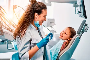 Uma dentista cuidando da sua paciente